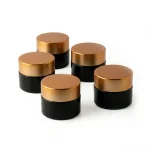 kemasan kosmetik POT COKLAT CAP GOLD varian warna hitam dengan gold cap bahan kaca